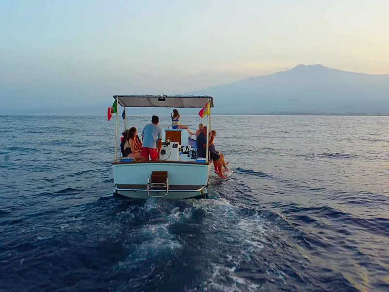 Barca Iside al tramonto lungo la costa di Taormina